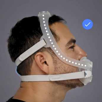 Side view of a man wearing a CPAP mask with headgear for sleep apnea therapy.
