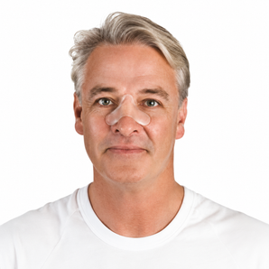 A man with gray hair wearing a white crew-neck t-shirt and a clear silicone nose pad on his nose.